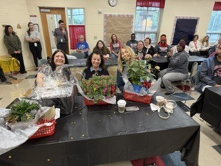 people at a table with flowers in front of them.