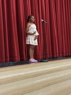 person standing in front of a curtain with  a microphone