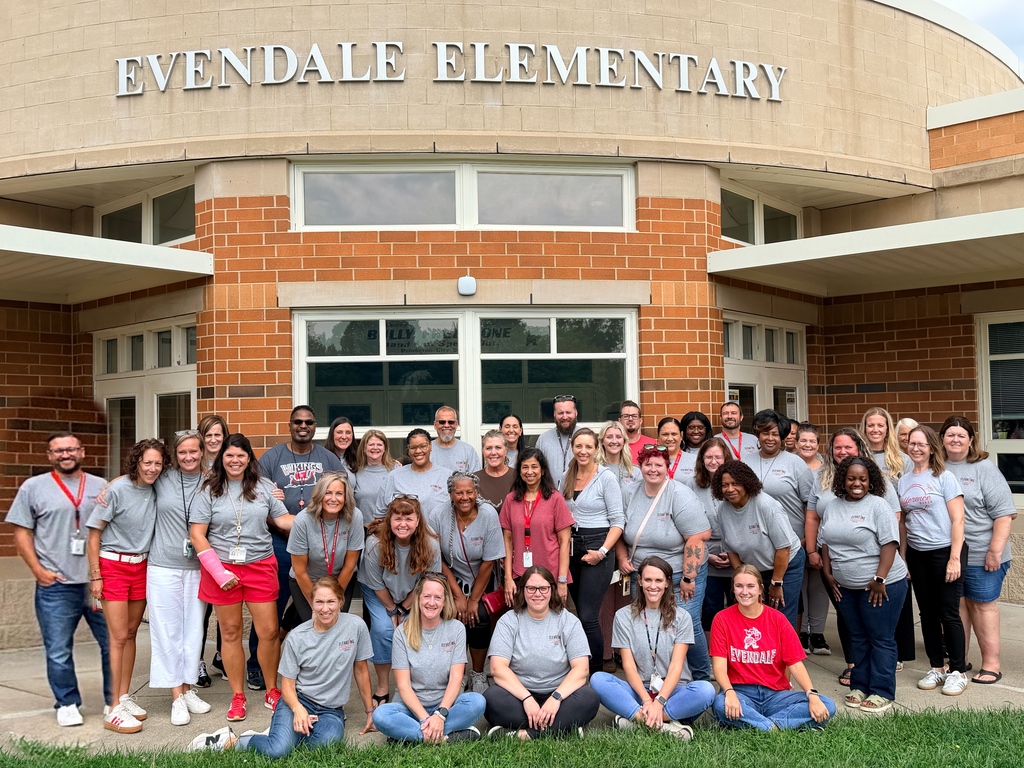 “Group photo of Evendale Elementary staff members posing outside the school entrance.”