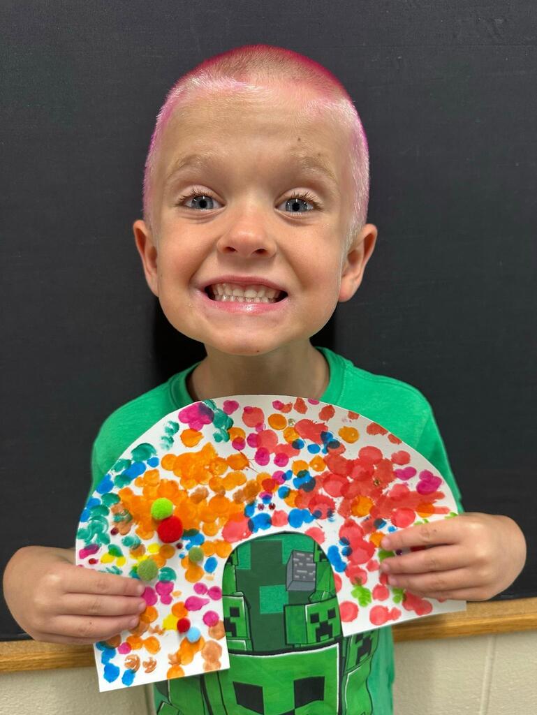 student holding a paper with colorful decorations