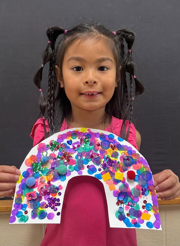 student holding a paper with colorful decorations