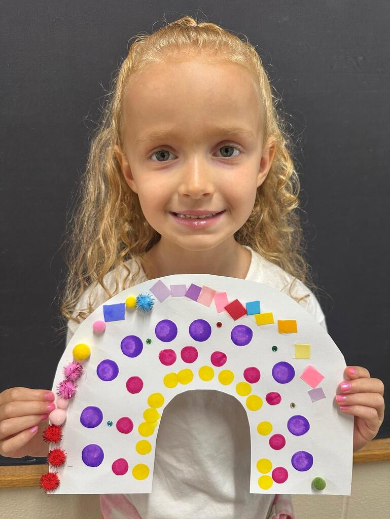 student holding a paper with colorful decorations