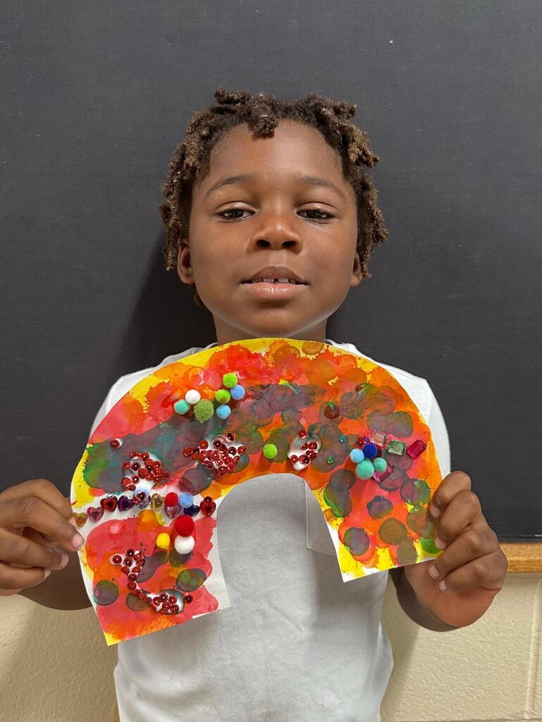 student holding a paper with colorful decorations
