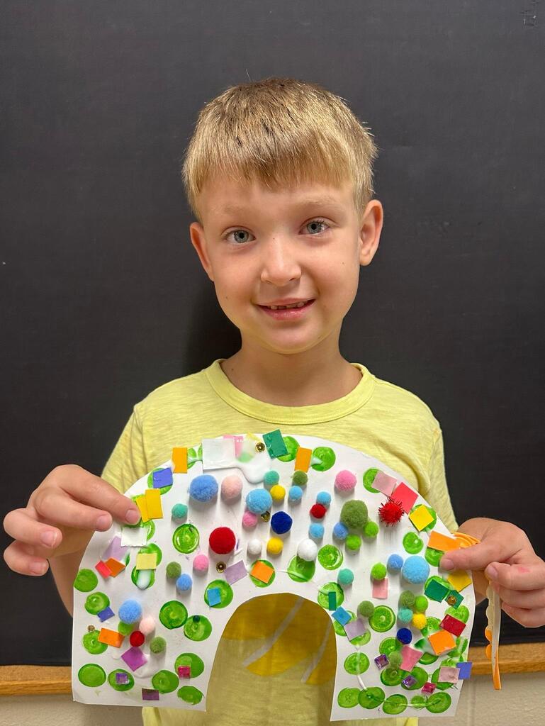 student holding a paper with colorful decorations