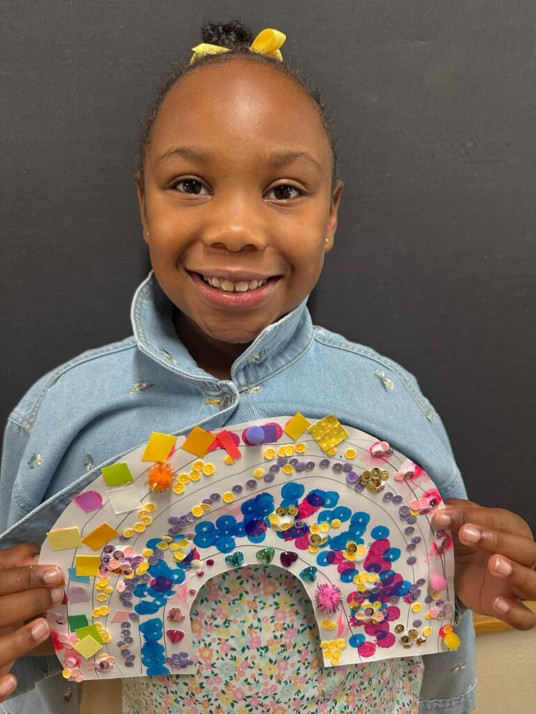 student holding a paper with colorful decorations
