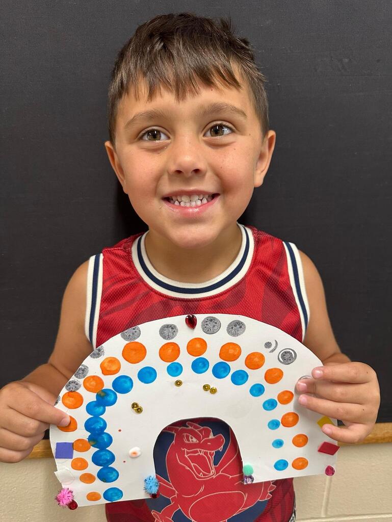 student holding a paper with colorful decorations
