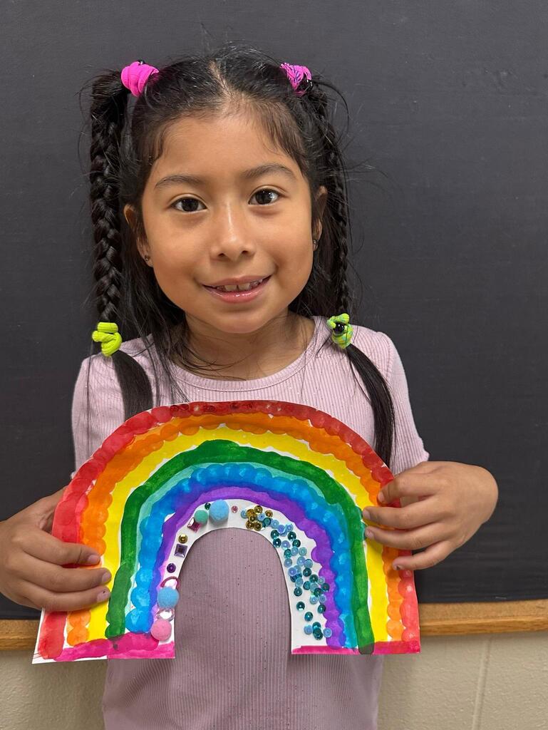 student holding a paper with colorful decorations