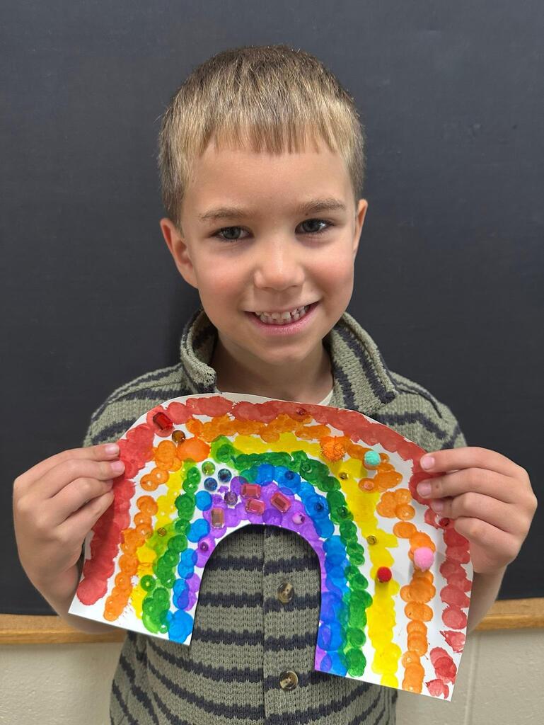student holding a paper with colorful decorations
