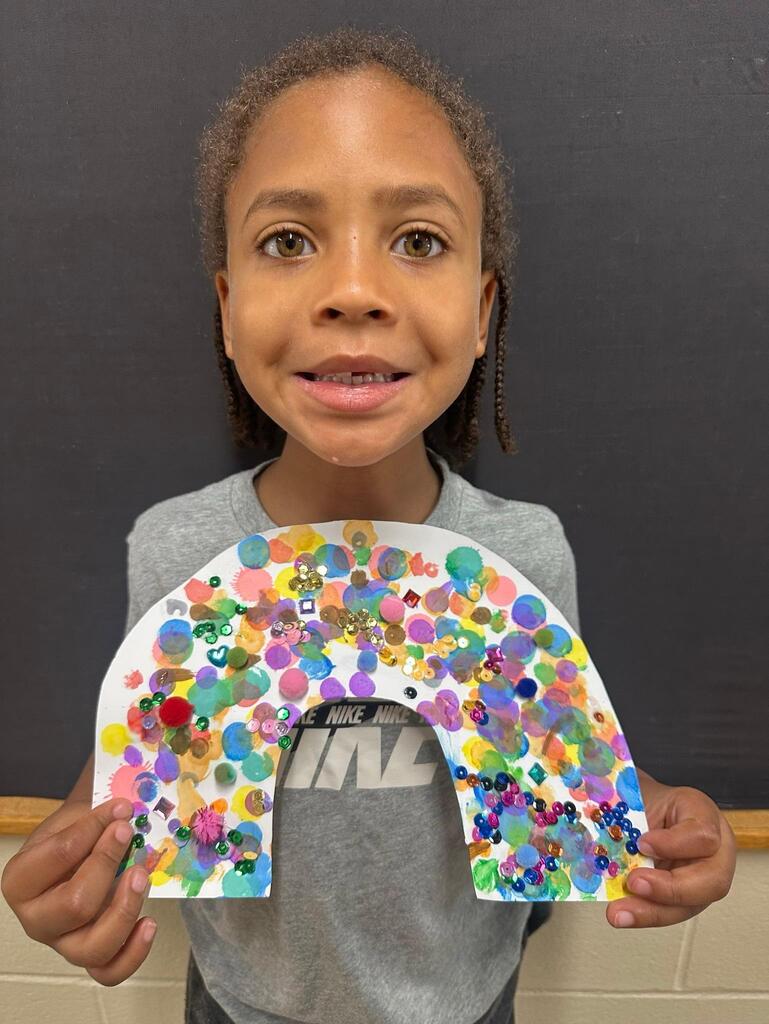 student holding a paper with colorful decorations