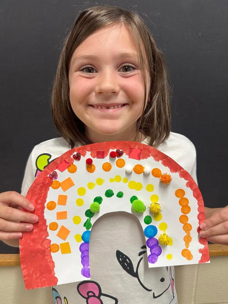 student holding a paper with colorful decorations