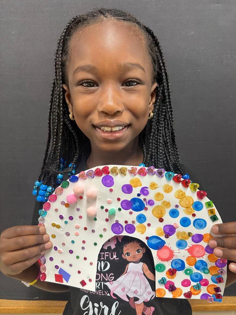 student holding a paper with colorful decorations