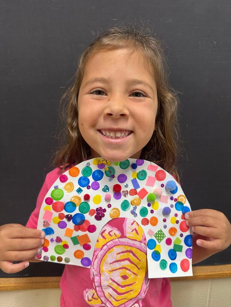 student holding a paper with colorful decorations