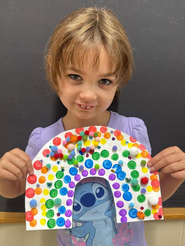 student holding a paper with colorful decorations