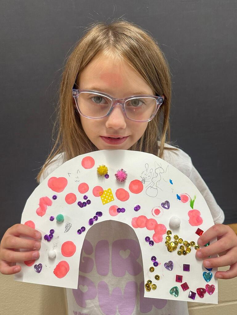 student holding a paper with colorful decorations