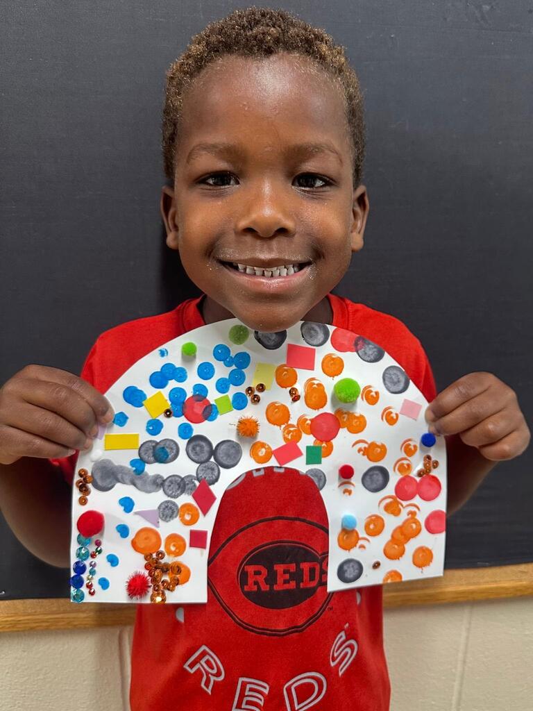 student holding a paper with colorful decorations