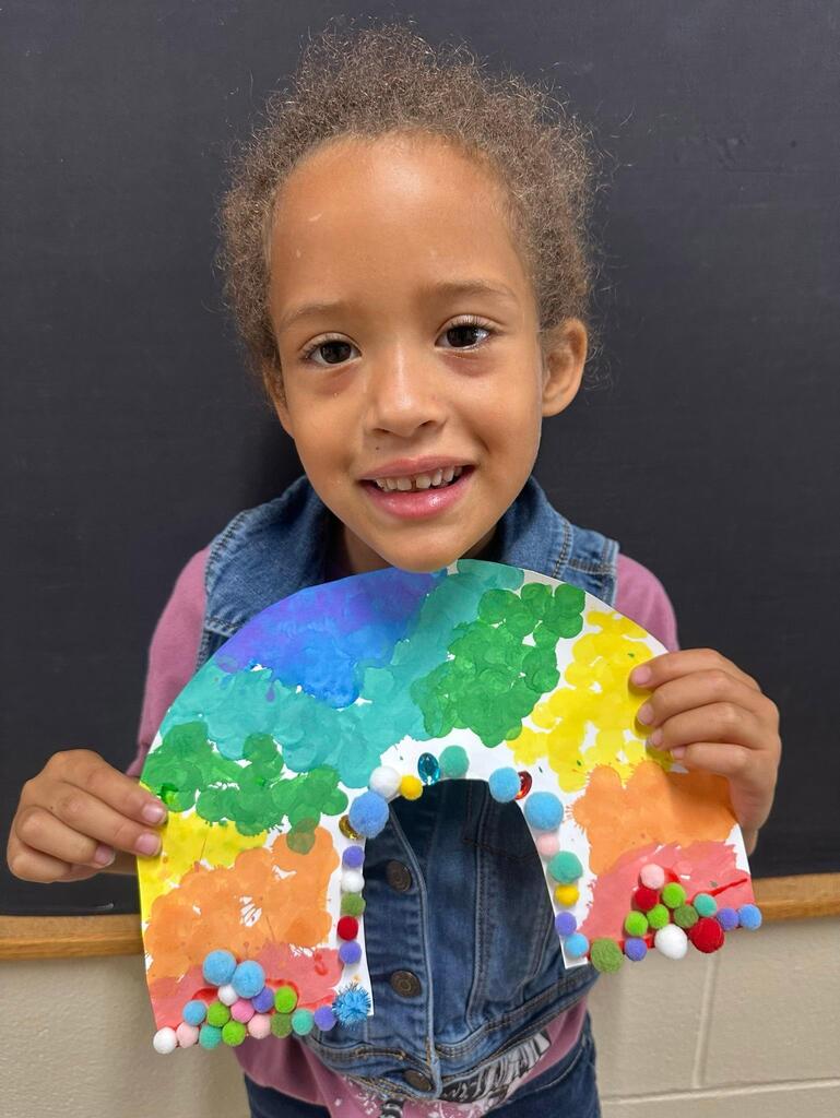 student holding a paper with colorful decorations