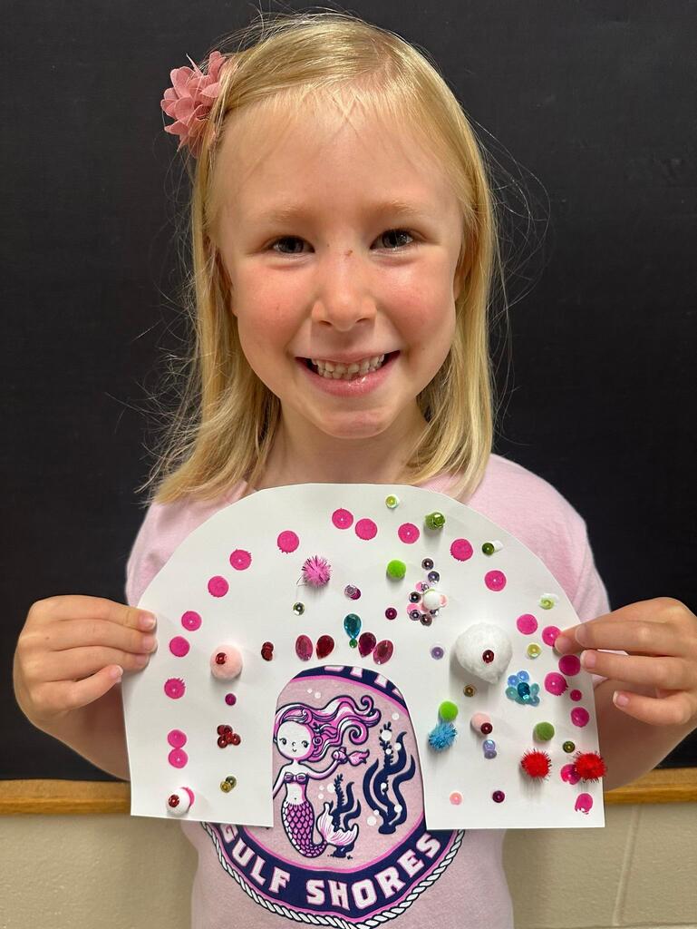 student holding a paper with colorful decorations
