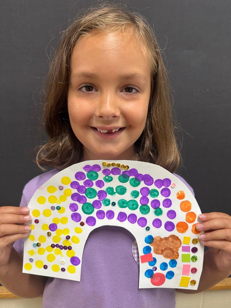 student holding a paper with colorful decorations
