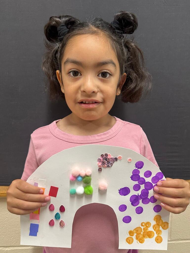 student holding a paper with colorful decorations