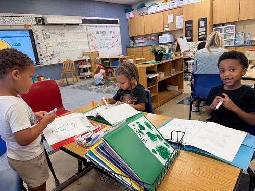 students in a classroom working in folders