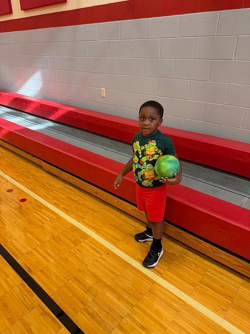 student in front of the bleachers in a gymnasium