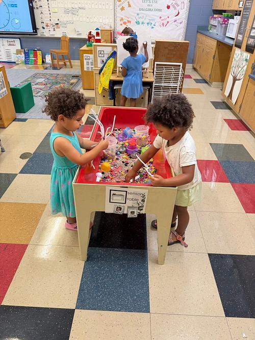 two student playing with a sensory table