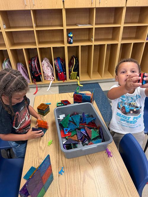 students sitting at a table with magnet tiles