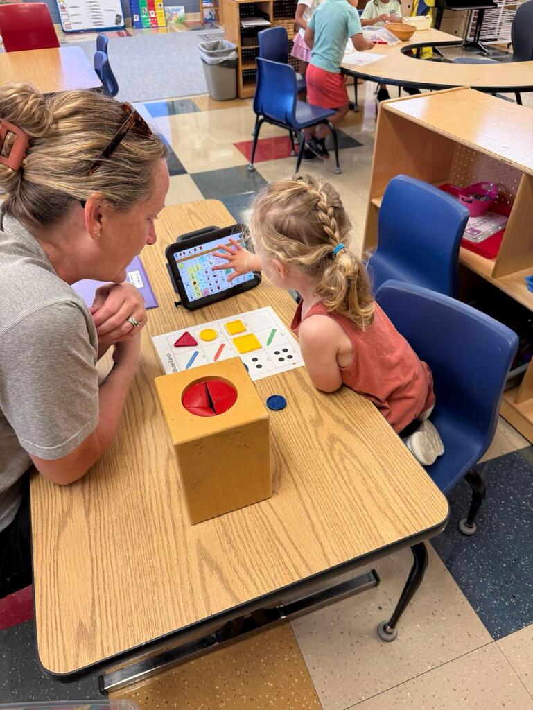 two people working with an ipad and blocks