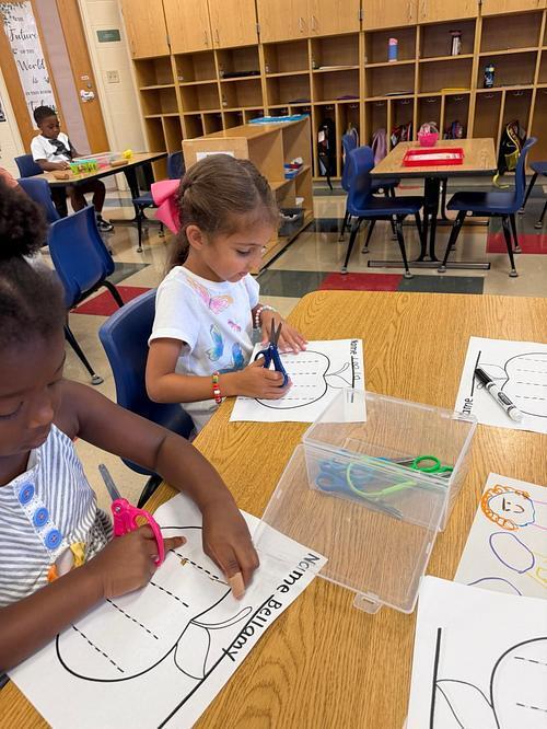 One student cutting paper