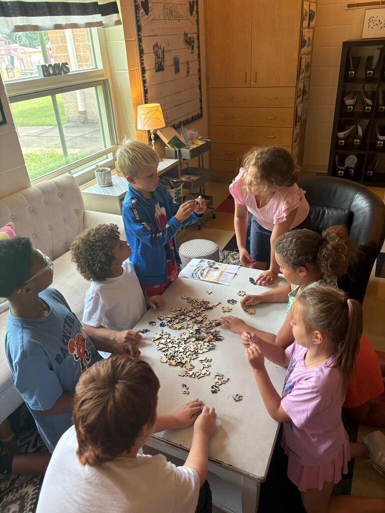 students at a table with puzzle pieces