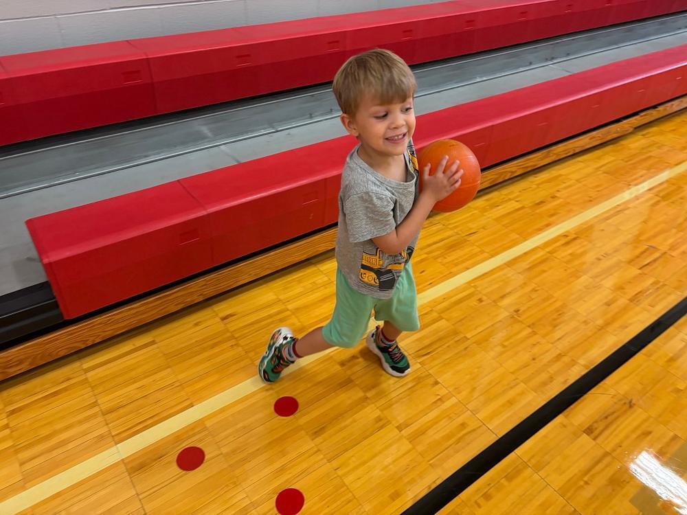 student in the gym holding  a ball