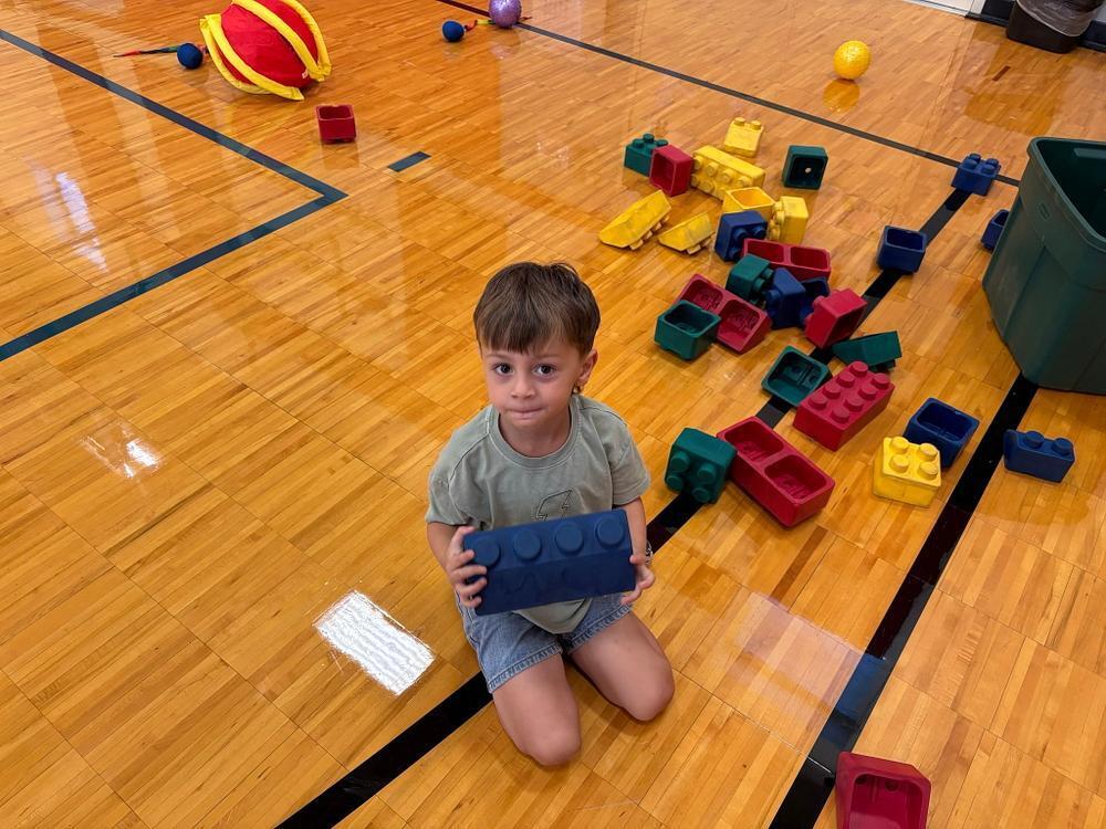 student in the gymnasium with large  plastic blocks 