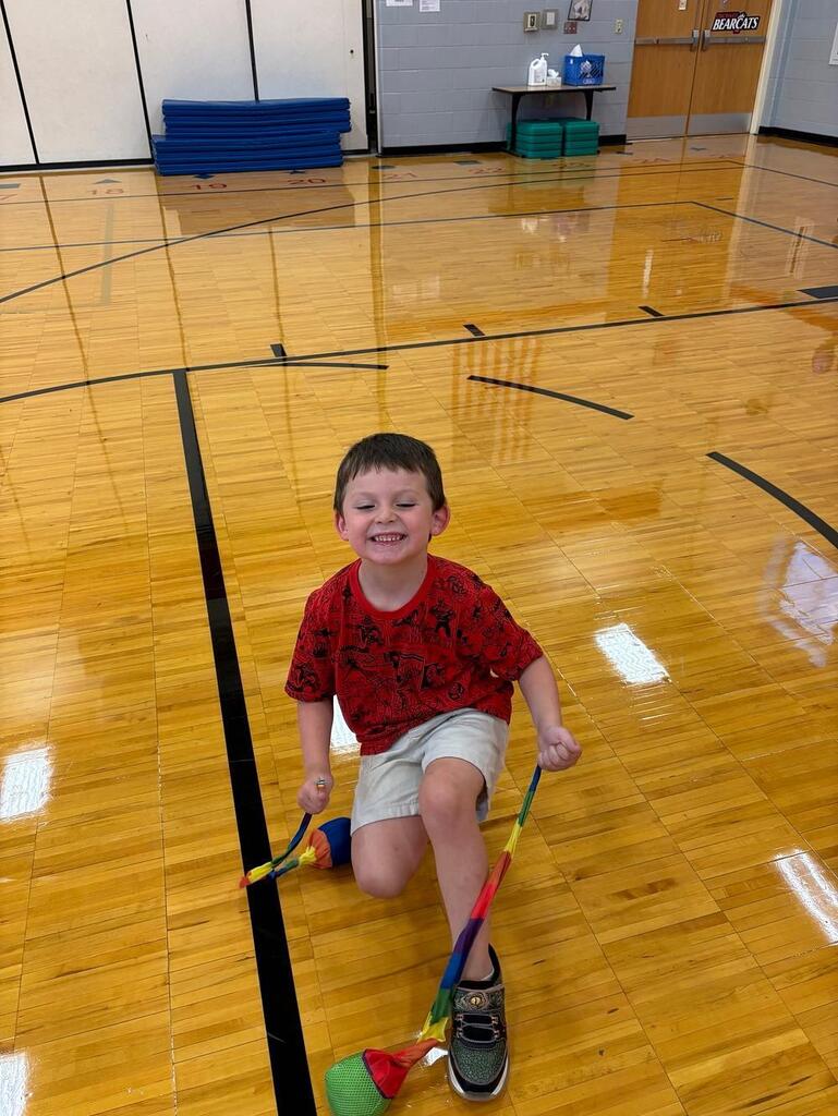 student in the gym with a rainbow rope