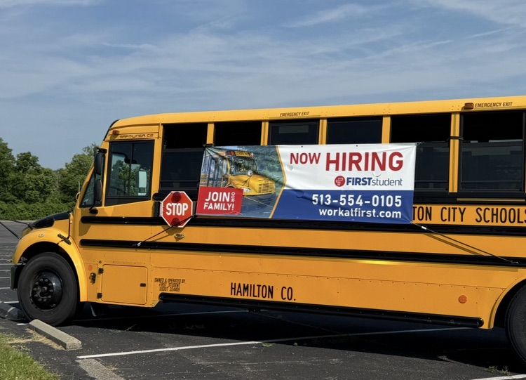 yellow school bus with sign saying now hiring
