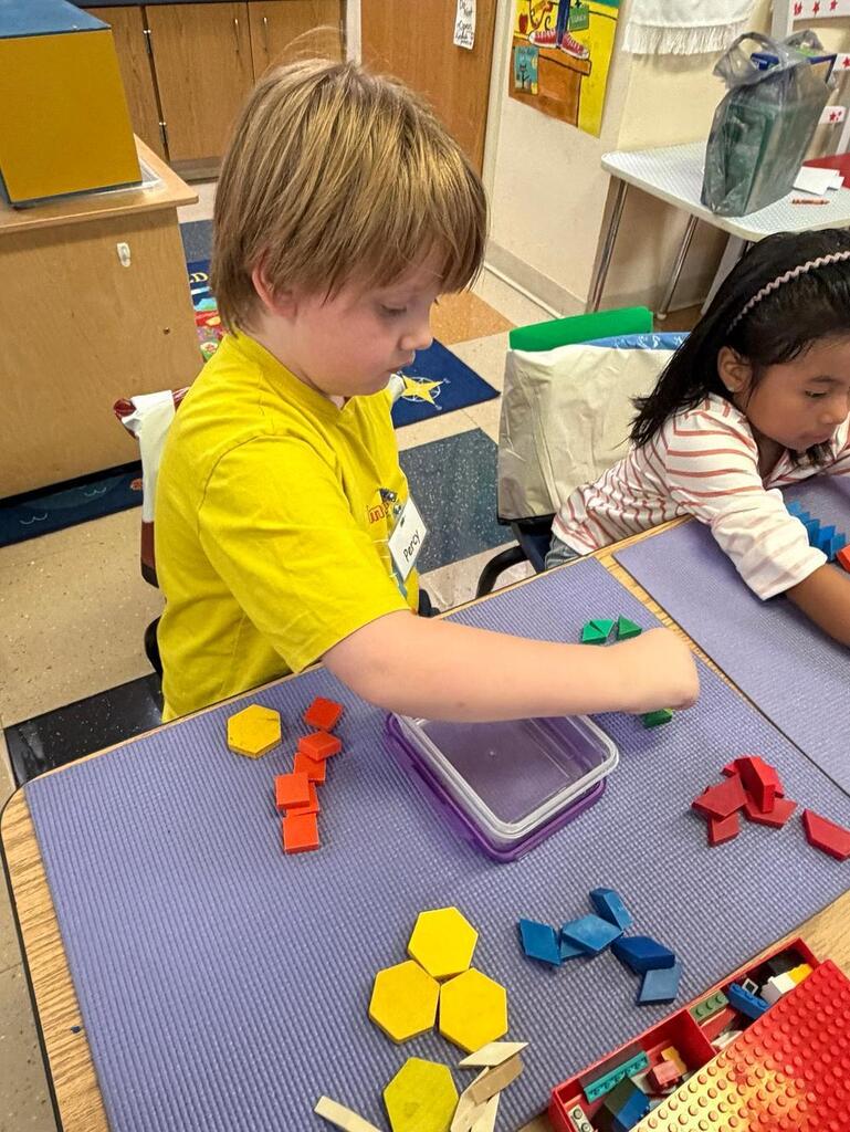 students at a table with math blocks 