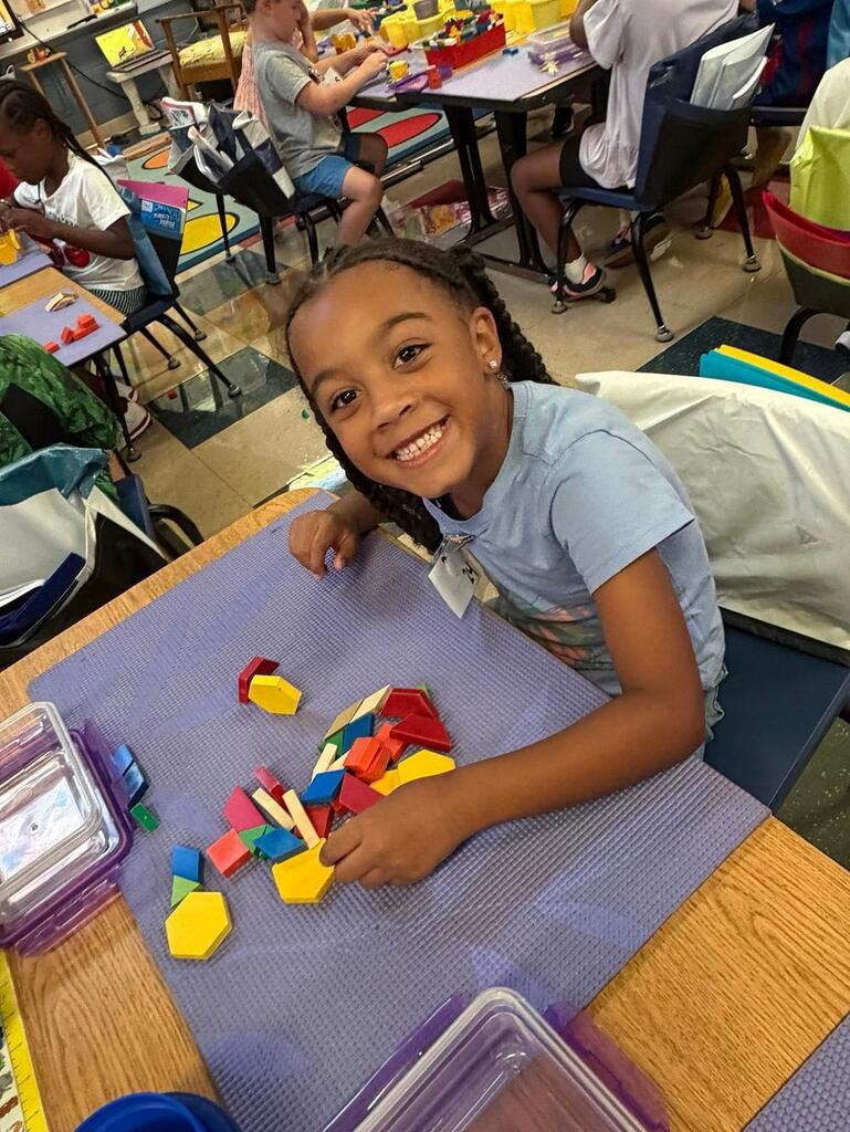 students at a table with math blocks 