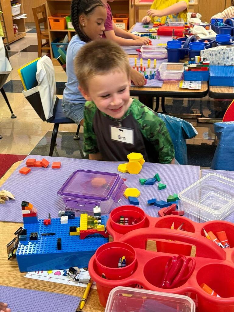 students at a table with math blocks 
