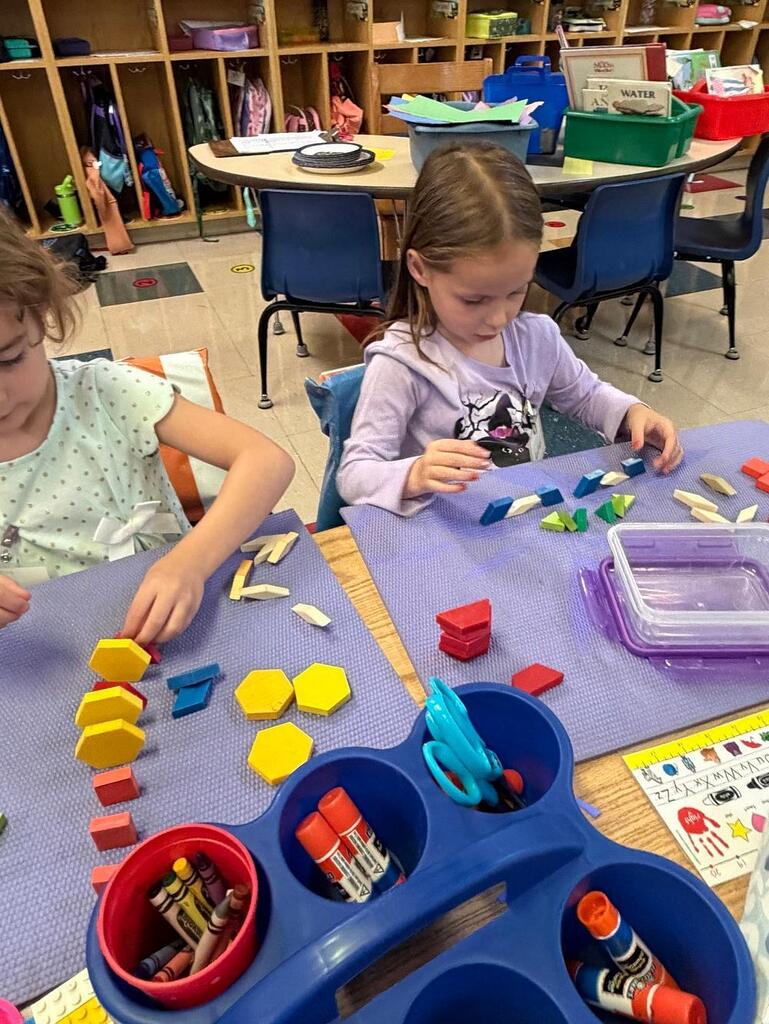 students at a table with math blocks 