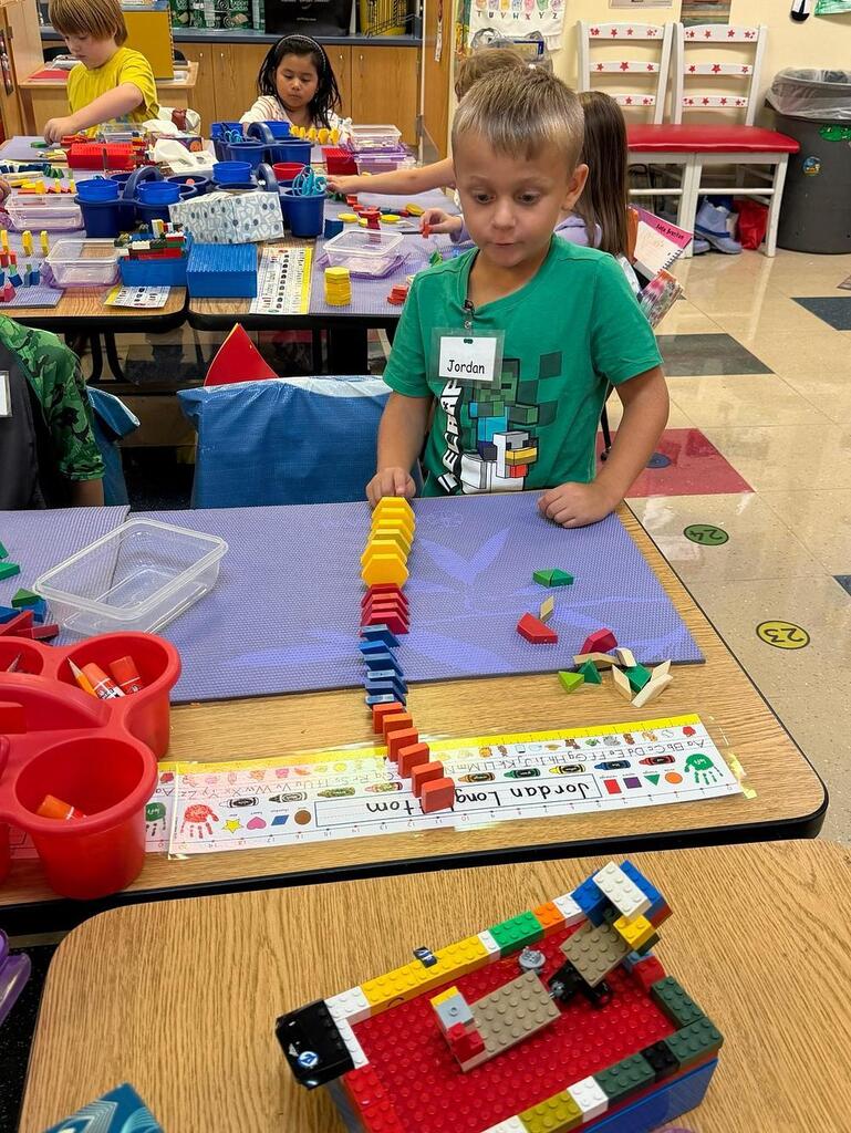 students at a table with math blocks 