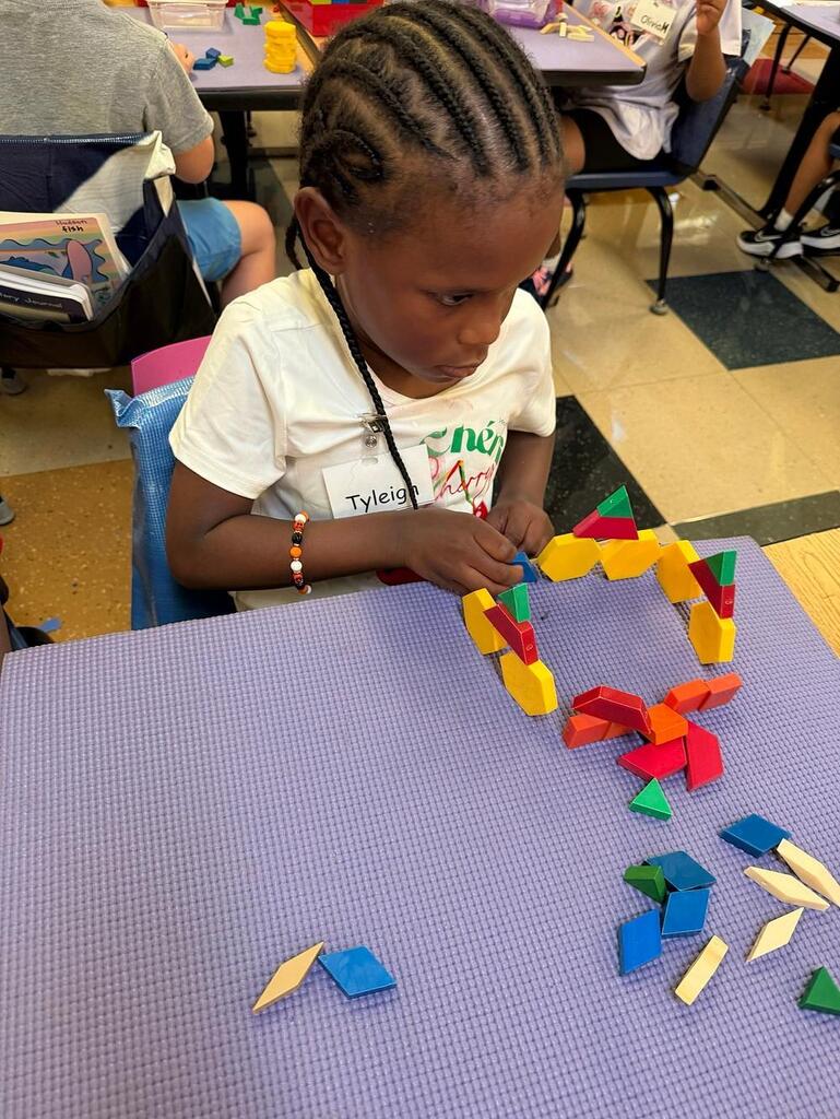 students at a table with math blocks 