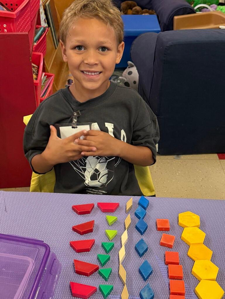 students at a table with math blocks 