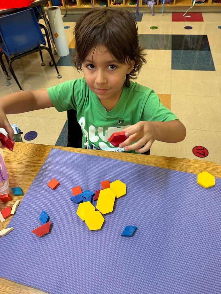 students at a table with math blocks 