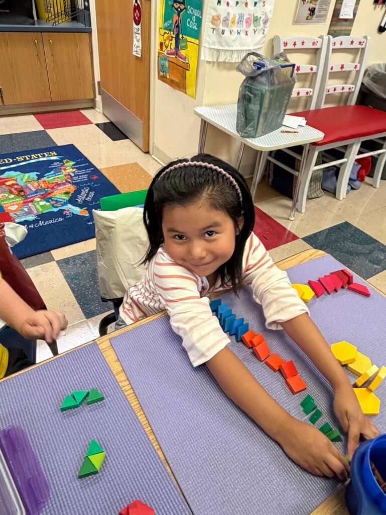 students at a table with math blocks 