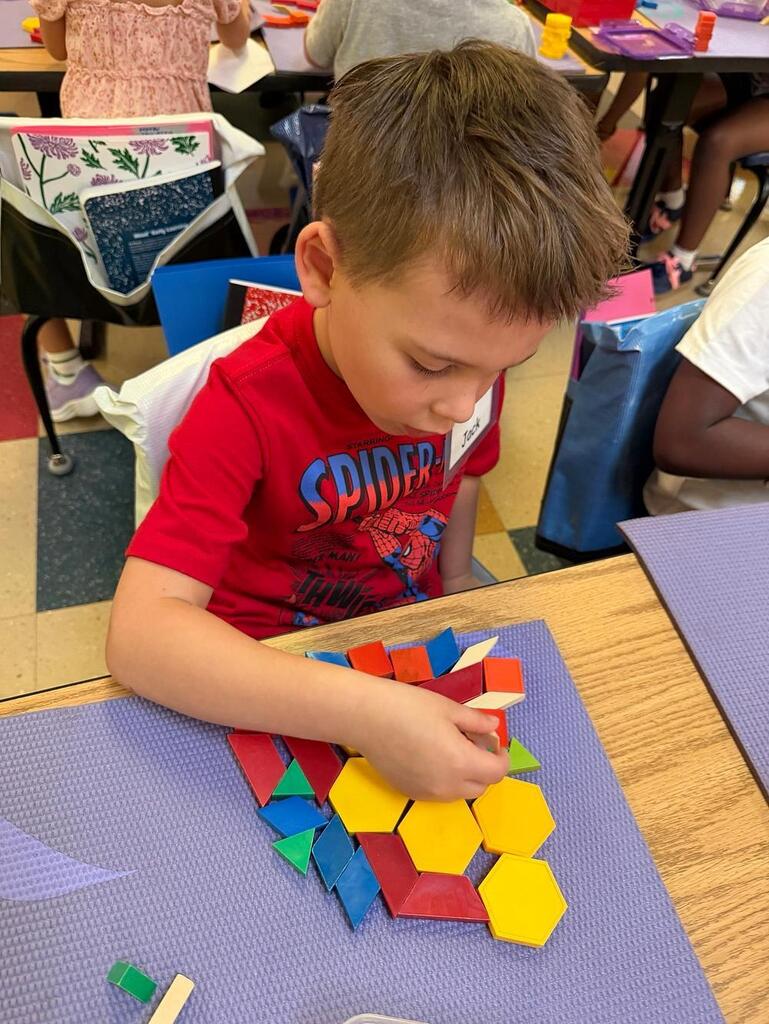 students at a table with math blocks 