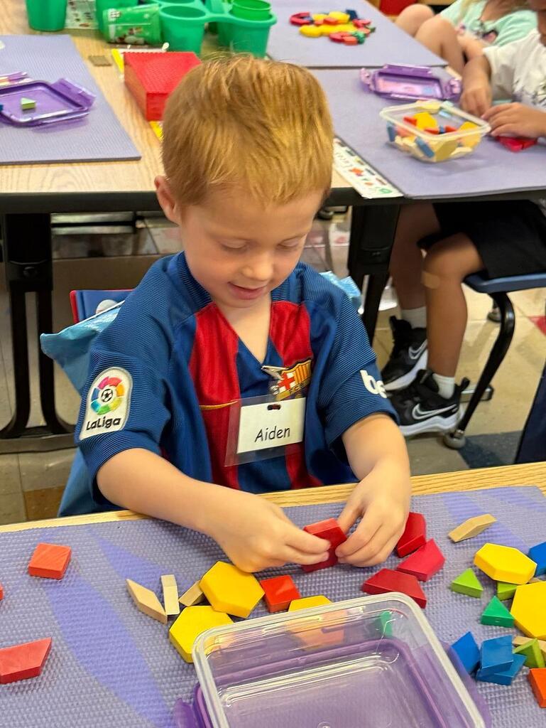 student at a table with math blocks