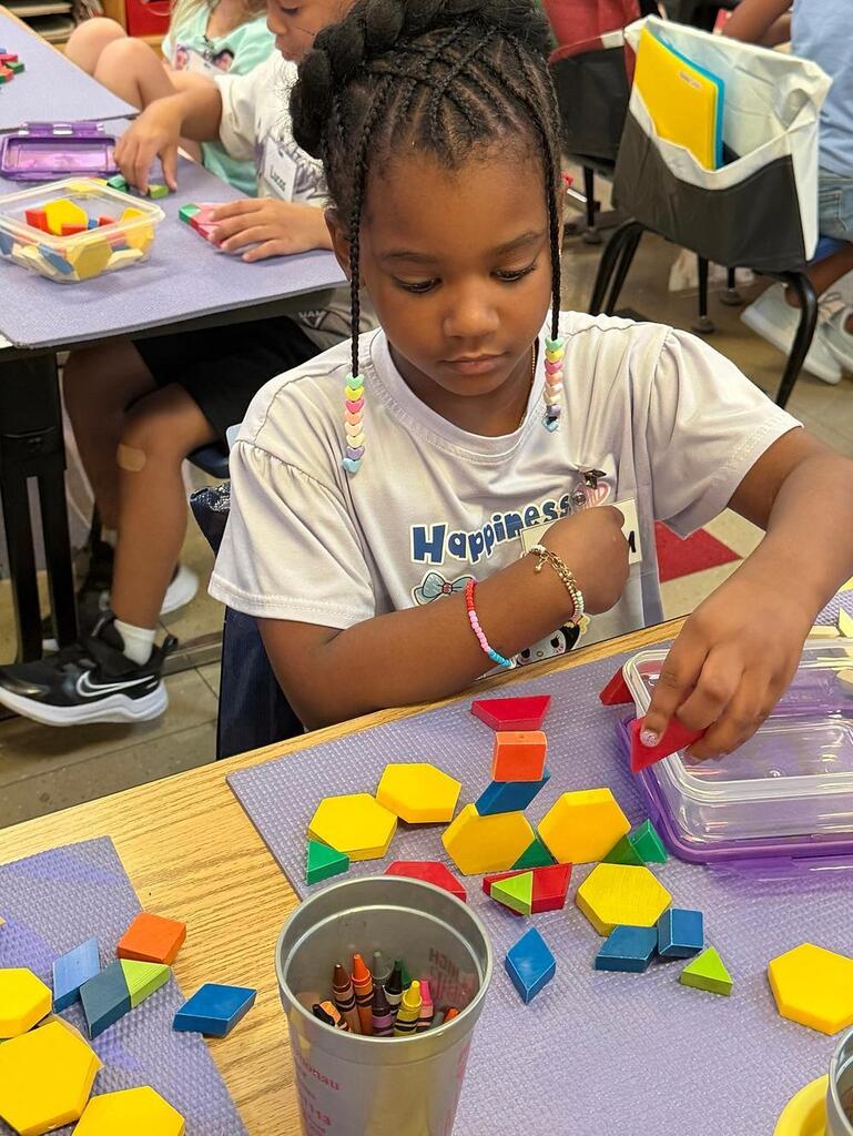student at a table with math blocks