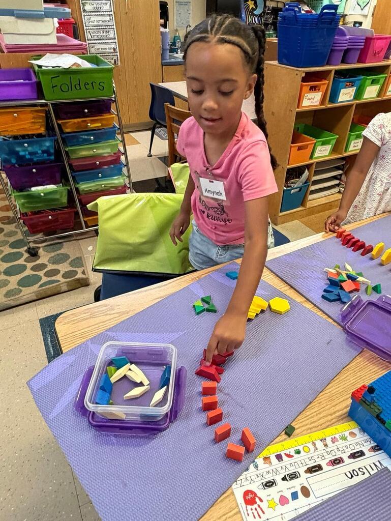 student at a table with math blocks