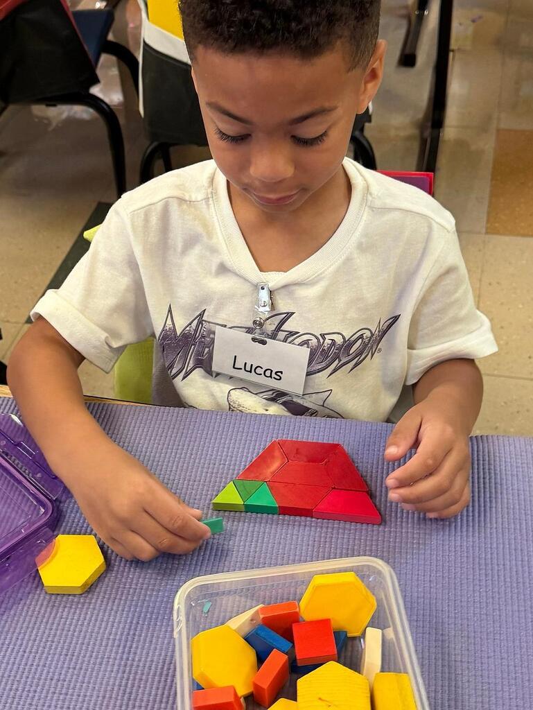student at a table with math blocks