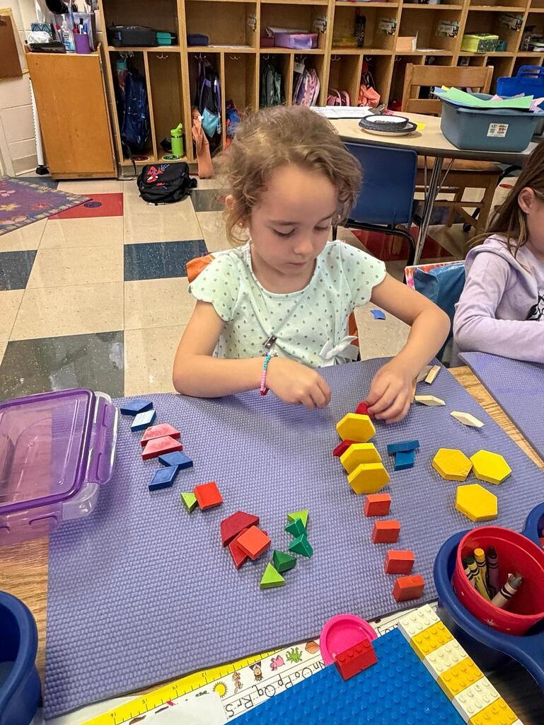 student at a table with math blocks