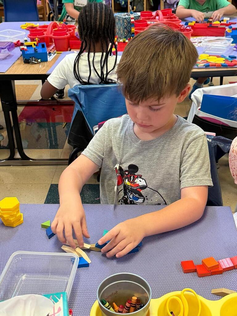 student at a table with math blocks